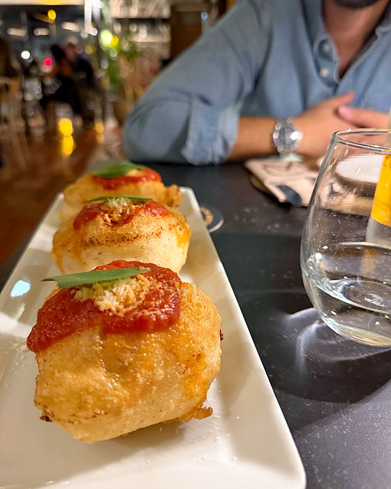 Un piatto di montanarine, mini pizze fritte con pomodoro e basilico