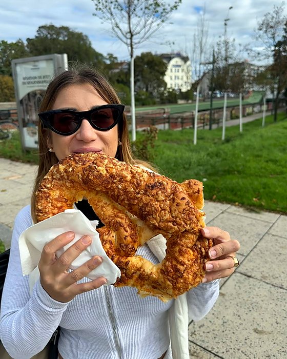 Un brezel gigante al formaggio mangiato in un parco