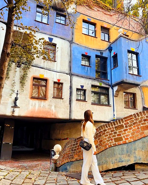 Una persona davanti alla Hundertwasserhaus, la casa colorata di Vienna