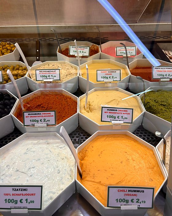 Vaschette di hummus e salse colorate al Naschmarkt, con i prezzi al etto