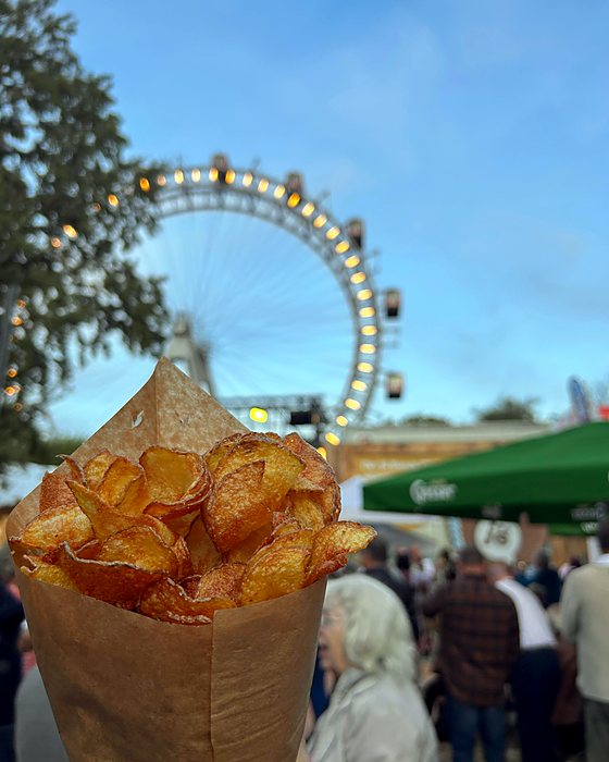 Un cartoccio di patatine fritte con la ruota panoramica del Prater alle spalle